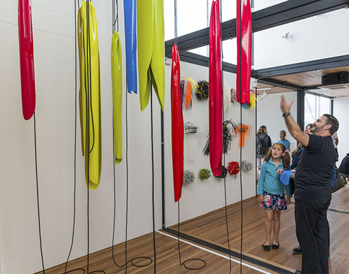 Andrew engaging with visitors at ArtBox. Pictured in the foreground is Helen Calder's Yellow, blue, red and black (installation view) 2013. Enamel paint, rubber cords. Reproduced courtesy of the artist