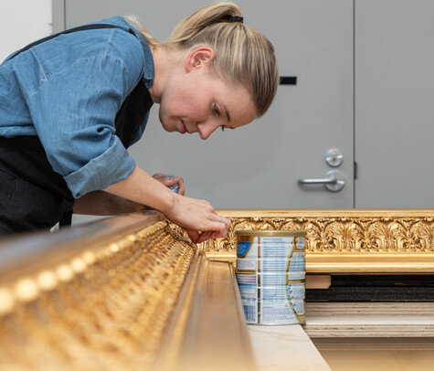 Anne-Sophie Ninino restores the historic frame of Burial in the Winter on the Island of Marken by Petrus van der Velden. Photo: John Collie