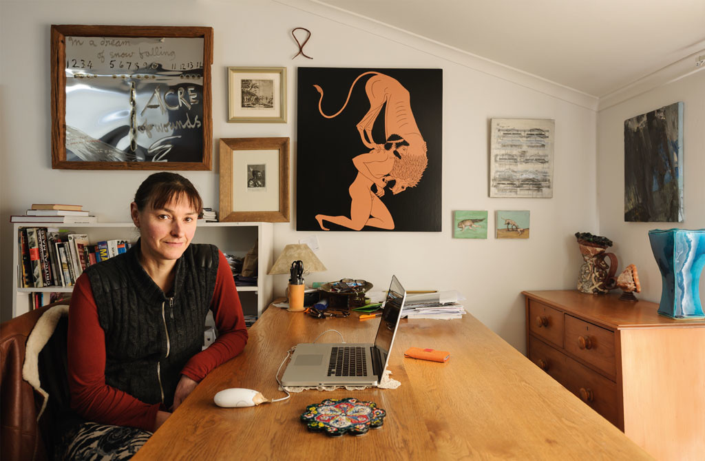 Marian Maguire with art from her collection, artwork from left to right: Ralph Hotere Acre of Wounds 1984; Unknown Morte del Capitano Cook c. 1775; Unknown Hoofd van een Krigsman uit Nieuw-Zeeland c. 1770; A piece of dry kelp given to me by my sister Teresa; Marian Maguire Untitled 2012, a more or less direct translation of a Greek vase painting by the Andokides Painter of Herakles wrestling the lion c.525–515BC; Nigel Buxton Bluebeard's Castle, Tranquillo c. 1997; Joanna Braithwaite Two untitled paintings 2001; Euan MacLeod Figure Coming 2002; On the chest of drawers are a jug by Simon Carroll, an English potter, bought from Form Gallery, and a vase by Merilyn Wiseman bought from Masterworks in Auckland. Photo: John Collie