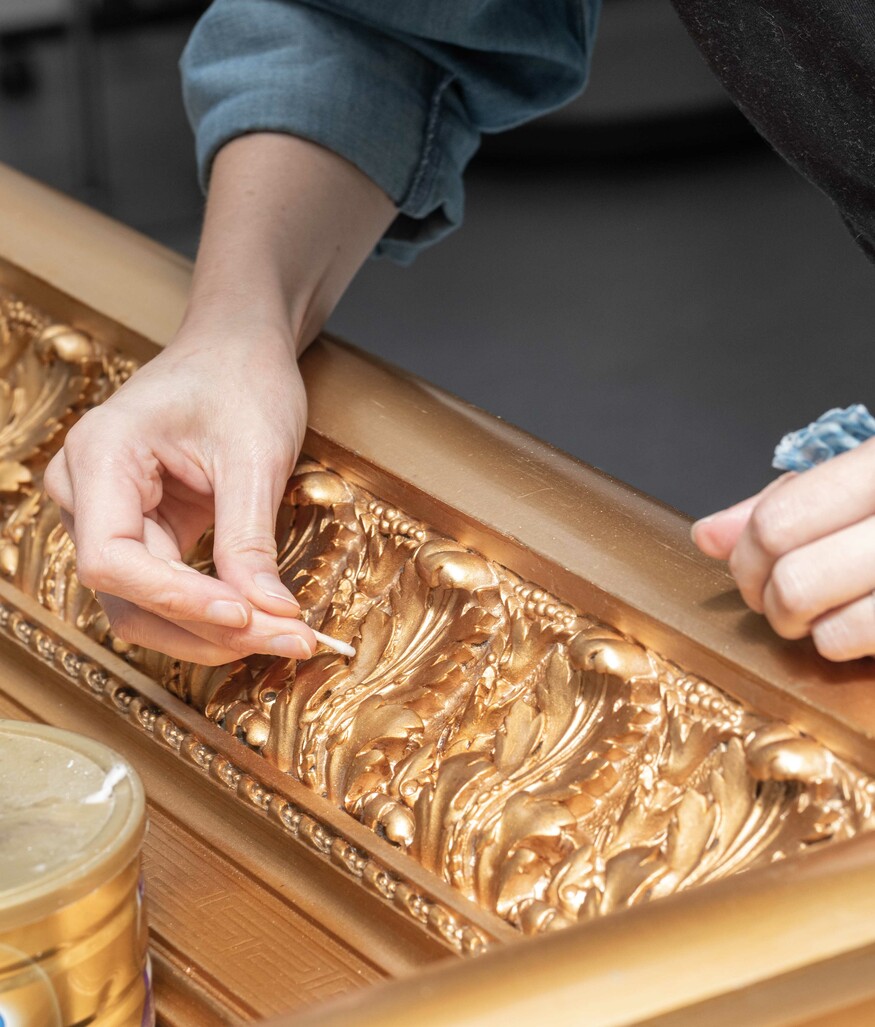 Anne-Sophie Ninino works on the frame of Petrus van der Velden’s Burial in the Winter on the Island of Marken [The Dutch Funeral].